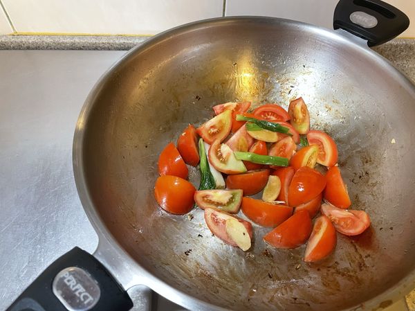 爆香蔥段、薑片，之後加入蕃茄稍微拌炒