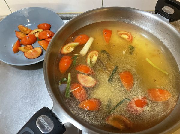 把一半蕃茄盛起備用，另一半加入水、米酒、味醂開大火煮滾，煮約十分鐘後可稍微用湯匙把蕃茄壓爛讓蕃茄融入湯底