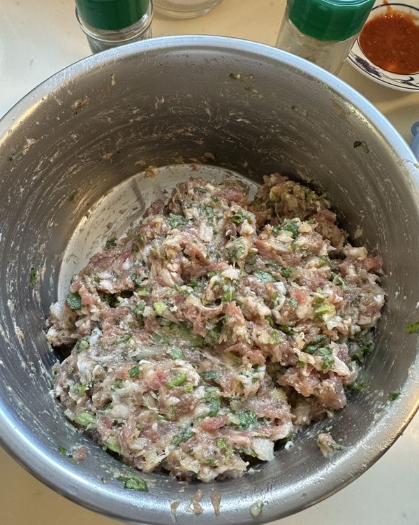 用手將所有材料充分攪拌揉捏，直到肉餡產生黏性為止。