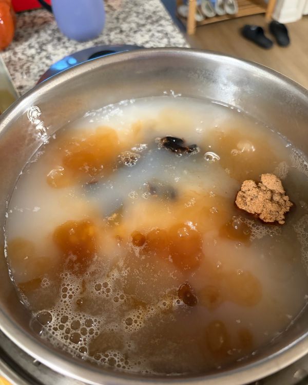 糯米粥煮好之後，倒入一杯黑糖，半杯紅糖，還有剛才的桂圓米酒全部倒進去