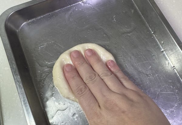 把鬆弛發酵後的小麵團壓扁扁
可以盡量壓大一點，這樣等一下比較好包料