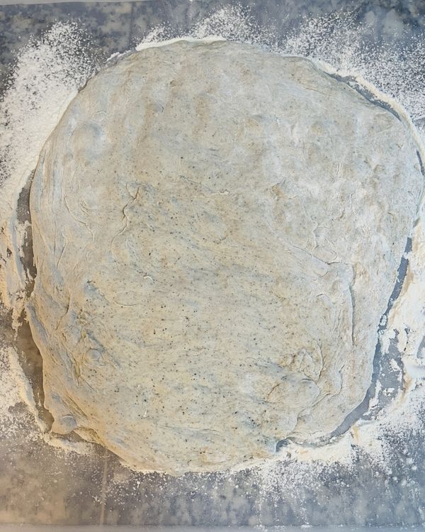 冰箱取出時可看到麵糰已膨的很明顯，表面撒點麵粉，倒到工作檯上；輕輕壓成長方型，不用很方，拍一下排氣；