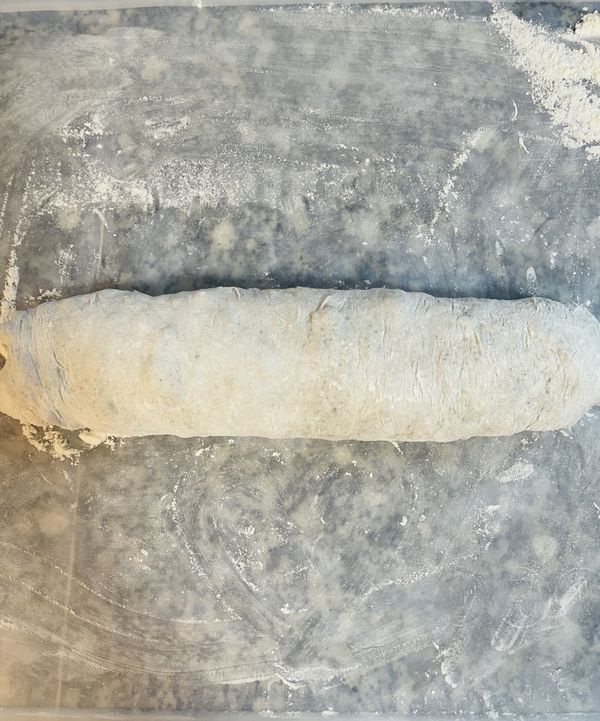 將麵糰摺三摺後滾成長條秤重；