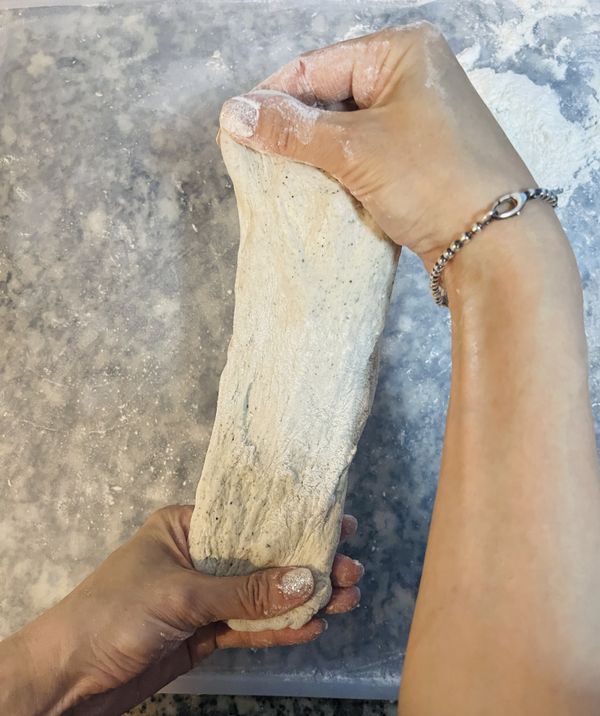 從第一顆滾圓的先整型，收口朝上，壓扁後拉成長條狀或用桿麵棍桿成麵皮；