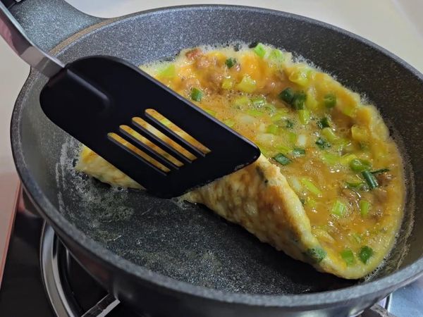 蛋液煎至蛋餅的形式還有底部金黃色的狀態就可以翻過來。