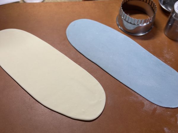 全材料放入麵包機「揉麵行程」攪拌15分鐘，攪拌機、手揉皆可。麵糰均分成兩份，一份加入藍色色粉+一兩滴水，揉勻顏色。

白、藍兩色麵糰，三桿三折排氣後桿成薄片，約3-5mm (不適合再更薄了