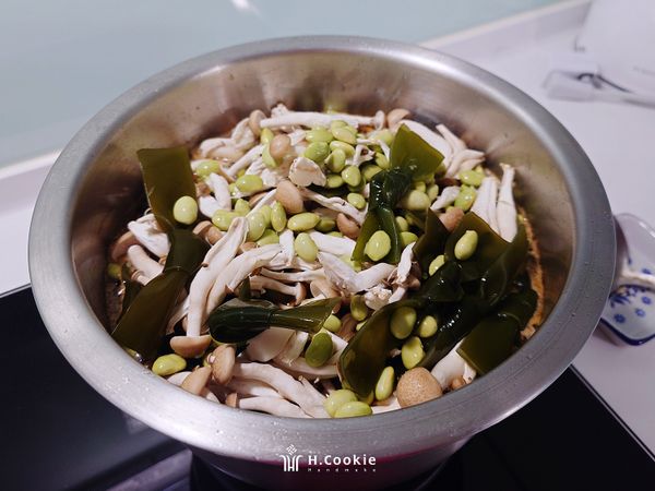 倒入毛豆、海帶、鴻喜菇至大湯鍋中，小火再加蓋悶煮約20分鐘（如口味太鹹可加入適量黑糖粉，如太淡可再加適量醬油膏調味）