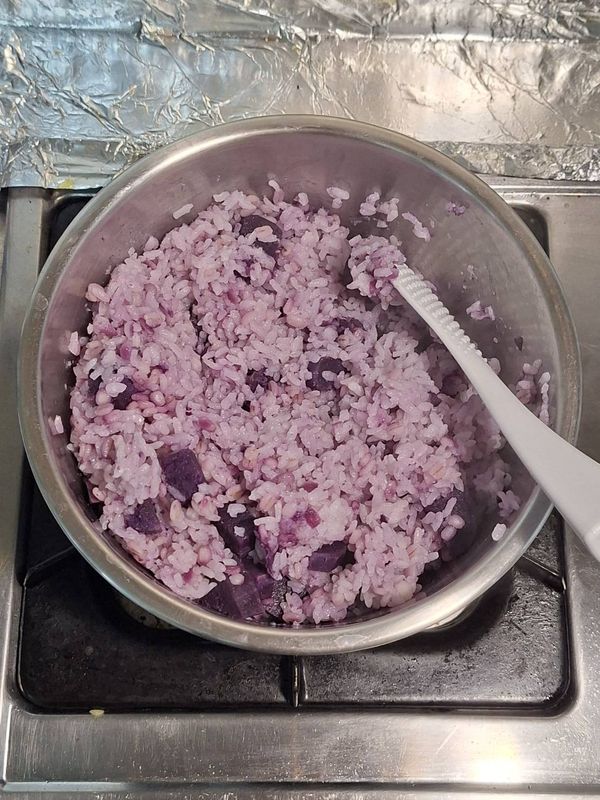 輕輕攪拌，讓一部分紫薯泥與大麥飯混合在一起，形成夢幻星空紫