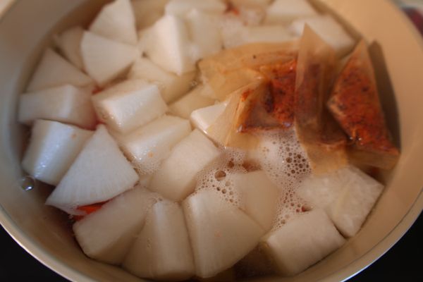 紅白蘿蔔切塊，放入湯鍋，加入高湯包和水，大火煮滾後轉小火煮20分鐘，或至蘿蔔變軟。
（如有浮沫將其撈除）