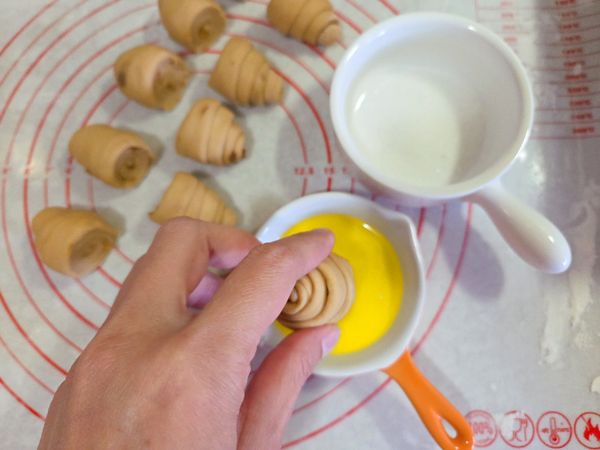 將捲好的麵糰對切，先沾上融化奶油