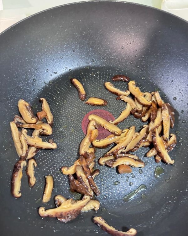 再來炒料：起油鍋下香菇絲，炒出香氣