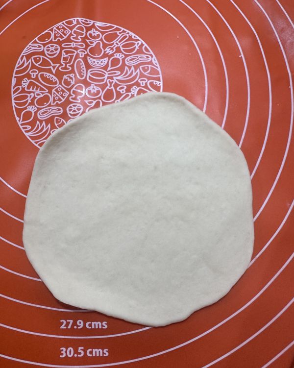 再用桿麵棍壓成中厚外薄的圓形麵皮