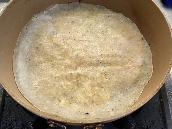 平底鍋稍微抹油，打入雞蛋，煎至半熟，蓋上蛋餅皮