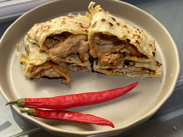 最後將豬肉片放上煎好的蛋餅皮捲起切半，就完成了！