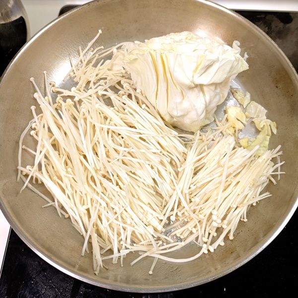 將高麗菜整個放上去煎，不切碎喔！金針菇也放上去，煎出水。