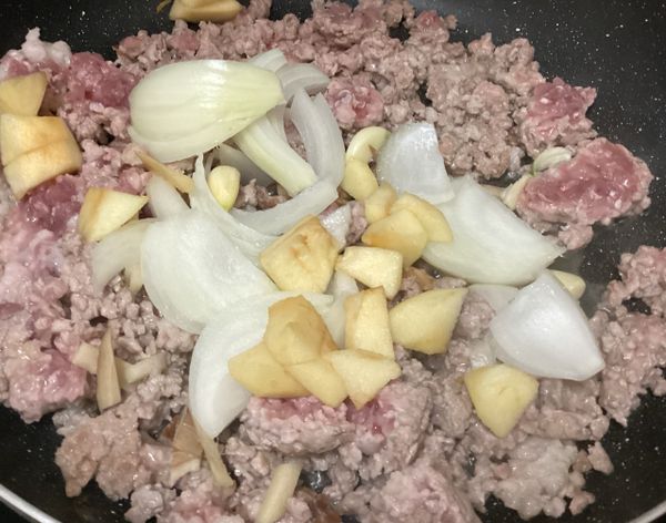 加入洋蔥、華盛頓加拉蘋果、蒜頭跟薑片一起煨煮，調整火力，煮至洋蔥變軟，蘋果釋放甜香。