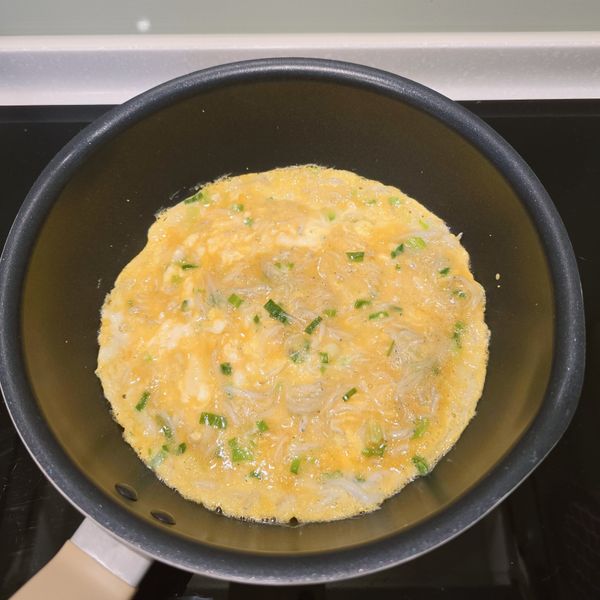 倒入蛋液材料，有一個小方法，拿筷子將局部蛋液攪拌一下加速凝固，流動蛋液變少，比較容易翻面。