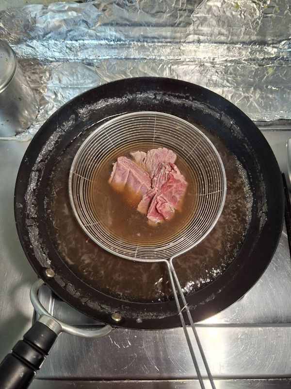 把燉好的高湯燒開，下入牛肉片