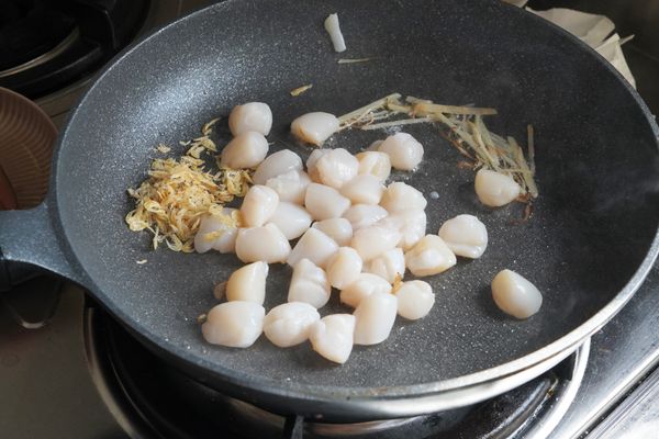 平底鍋加油後小火炒薑絲至香味出來，加入蝦米及海灣貝柱拌炒。