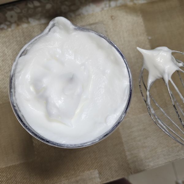 啟動打蛋器先以慢速打幾秒再漸漸轉高速，過程分幾次加入砂糖，想要提升成功率可加入酸性的白醋或檸檬汁（不加也可以）。打發程度如圖中乾性發泡，提起取出打蛋器蛋白自然呈現挺直的尖端即可。