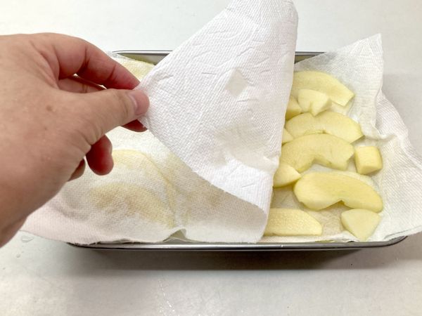 取出後鋪在餐巾紙上，輕壓吸乾蘋果片多餘的水分。