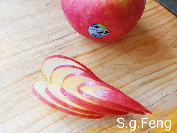 4.華盛頓富士蘋果取1/6顆大小2片；每一片由兩側底層約0.3公分處向內切(呈V型)切至交會點，依同樣方式，逐一向上切5層，完成後由一向往前推，即可呈現有層次的愛心蘋果花，其餘的蘋果切丁；切完的愛心蘋果花與蘋果丁過一下鹽水，防止氧化變色。(鹽水:冷開水500cc+1茶匙鹽(食材外的份量)。