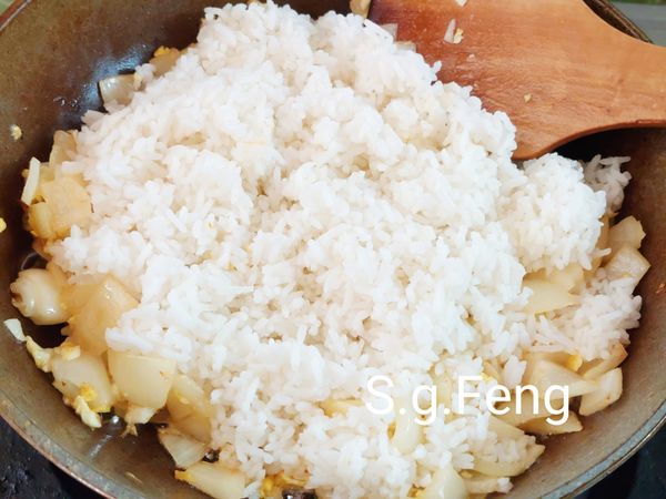 12.加入白飯，將白飯拌散，翻炒至米飯散開蓬鬆（一粒一粒散開）。