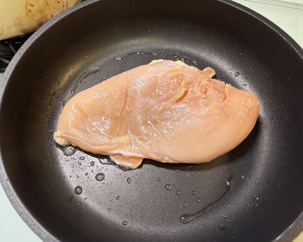 雞胸抹上鹽和灑上白胡椒粉，可以的話，至少醃30分鐘或更久一些。
平底鍋加油燒熱後，放入雞胸。