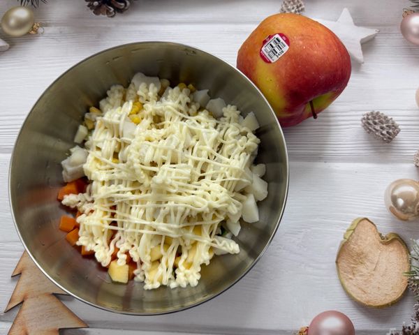 將所有沙拉的食材，包括蘋果丁、玉米粒、馬鈴薯塊、紅蘿蔔丁、小黃瓜丁和雞蛋塊加入碗中，最後擠上美乃滋。