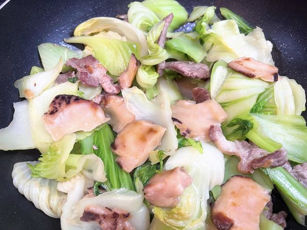 加入大芥菜拌炒，加鹽，加入泡香菇的水。