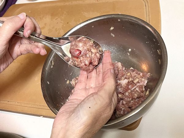揉丸子
以湯匙輔助將絞肉餡舀成球型，摔打拍揉成丸子。