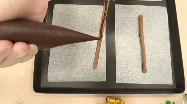 出爐後放涼備用，在可可麻糬棒上擠上巧克力醬，固定於烘焙紙。