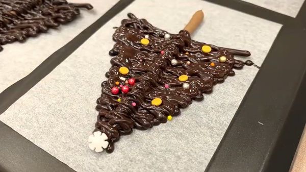 再畫第二層、第三層，巧克力尚未凝固前放上小糖珠裝飾，撒上食用珠光粉。