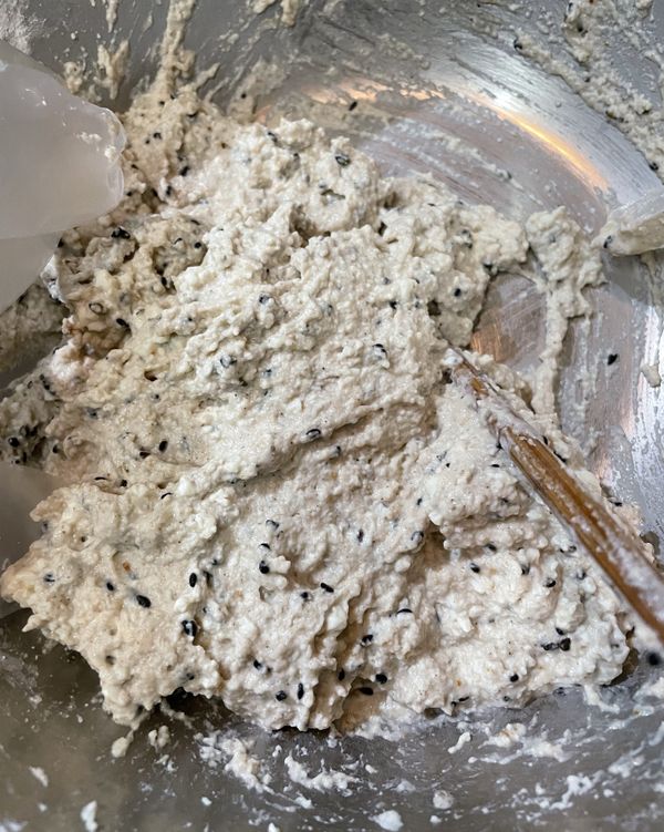 壓好的豆腐放入盆子裡面，加入五香粉、胡椒鹽、糖和低筋麵粉、玉米粉、胡椒鹽、黑芝麻粒、七味粉、泡打粉，攪拌均勻至所有材料充分混合。