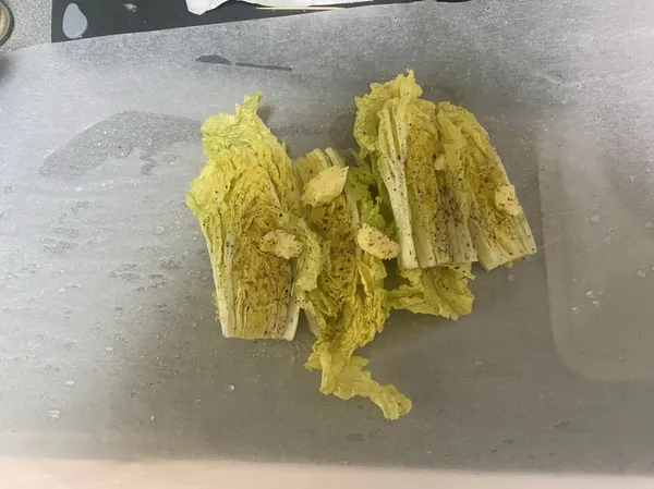 娃娃菜根部切除後對切，切面朝上
刷沙拉油，撒上調味黑胡椒、鹽巴、蒜香粉，放上無鹽奶油