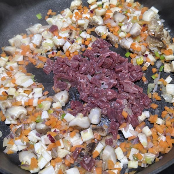 放入冬菇和蔬菜翻炒片刻後加入牛肉炒勻至半熟，注意不需炒至全熟
