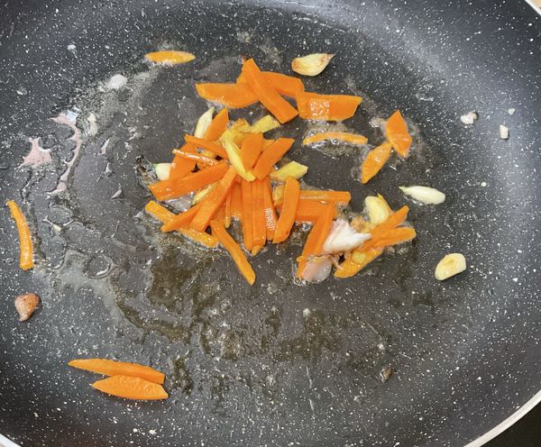 沙拉油炒蒜頭、薑片跟胡蘿蔔
