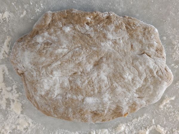 用手掌把麵糰拍平，以去除大氣泡