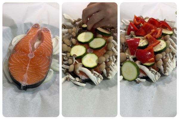 盤上鋪料理紙 ➔ 鋪上洋蔥絲墊底 ➔ 放上擦乾的鮭魚 ➔ 隨意堆疊剩下的蔬菜，淋上少許橄欖油，灑上黑胡椒與鹽。