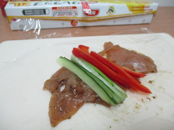 雞胸肉清洗乾淨後,把比較厚的部分攤平切薄-用米酒、味醂、醬油膏拌勻醃製兩小時~
接著利用保鮮膜把它拉開--把雞肉捲包入紅甜椒絲, 小黃瓜絲,葱絲後,捲起來備用~