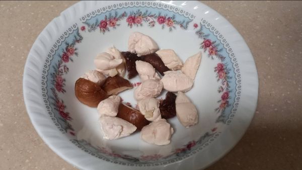 把雞肉丁和香菇在碗中鋪好