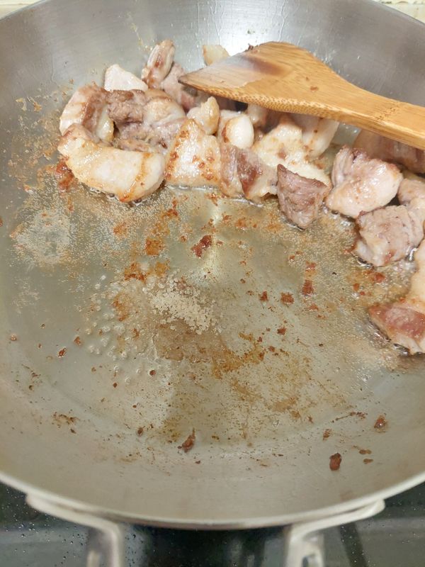 將肉推至旁邊，下糖，讓糖變色後再將肉與糖拌勻，讓肉均勻裹上漂亮的糖色