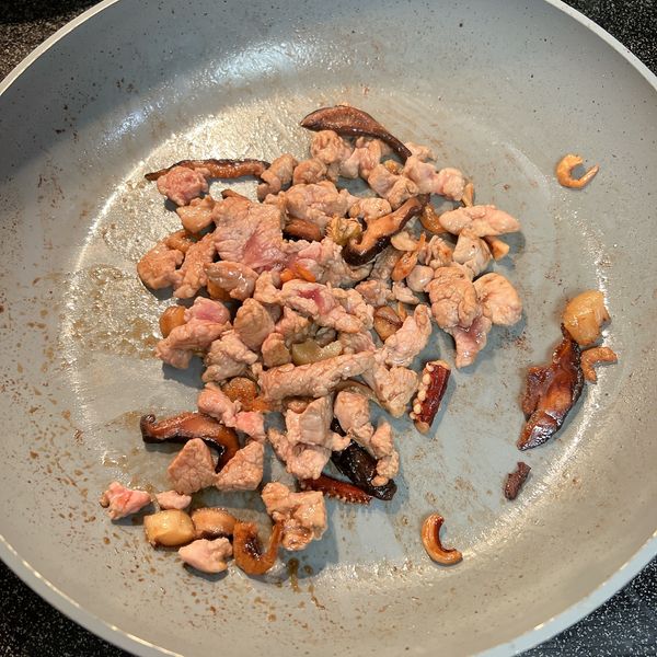 香菇、乾貨、豬肉炒差不多熟了以後，盛盤備著