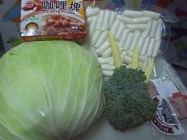 準備好所有的材料: 
牛頭牌咖哩塊（辣味）這樣的獨立包裝很方便，也不沾手唷~
高麗菜 1/4顆
玉米筍  3 條
綠花椰菜 小顆半顆
市售韓式年糕 一包
火腿肉  少許
松露巧克力  3顆