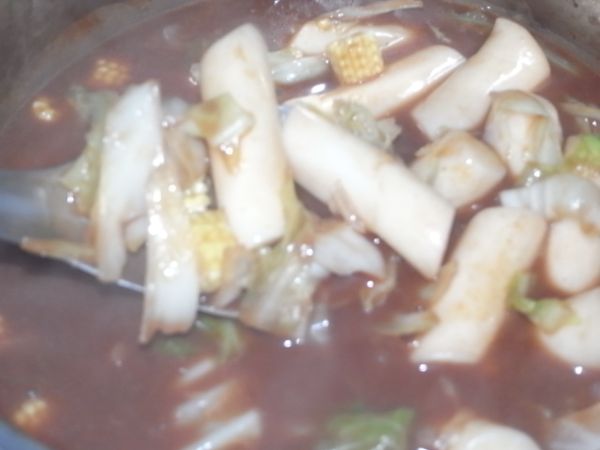 而後加入一些水，攪拌均勻後 放入年糕將年糕燒到軟。