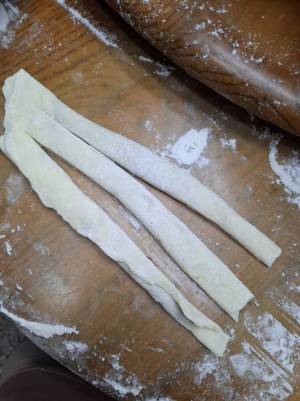 將麵團桿開成大長方形，如果家裡位置不夠，可以分成六份，每份約99g，也是桿開成小長方形