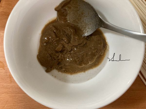 將麻醬加煮滾的水1匙，邊加水邊順時針用湯匙拌開，再依序加入黑糖、醬油、蒜泥、黑醋、香油拌開。