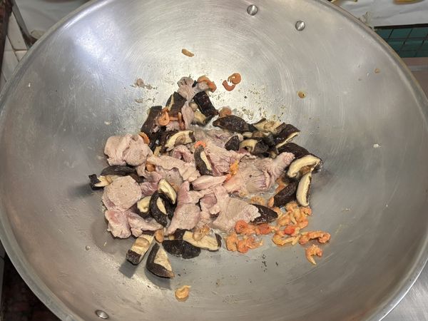 蝦米洗淨後泡米酒瀝乾（米酒備用）、乾香菇洗淨後泡水瀝乾切片（香菇水備用）、肉片洗淨後備用
下鍋大火炒香蝦米、乾香菇、肉片