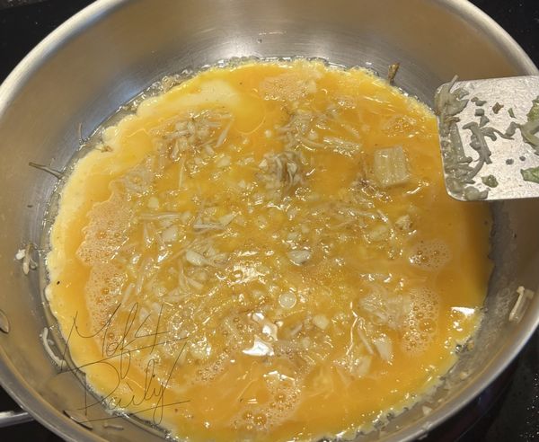 加入蛋液，待蛋液慢慢凝固，將炒好的蒜末和金針菇均勻放入蛋液中