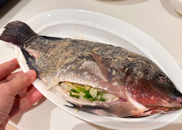 3. 將蔥末、蒜末、薑末、洋蔥絲、胡椒鹽混合塞入魚的肚子